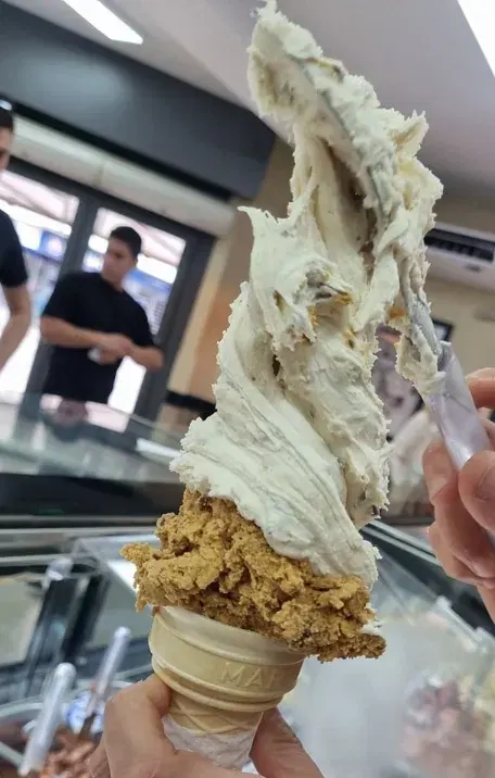 Cucurucho de crema y dulce de leche, servido bien alto